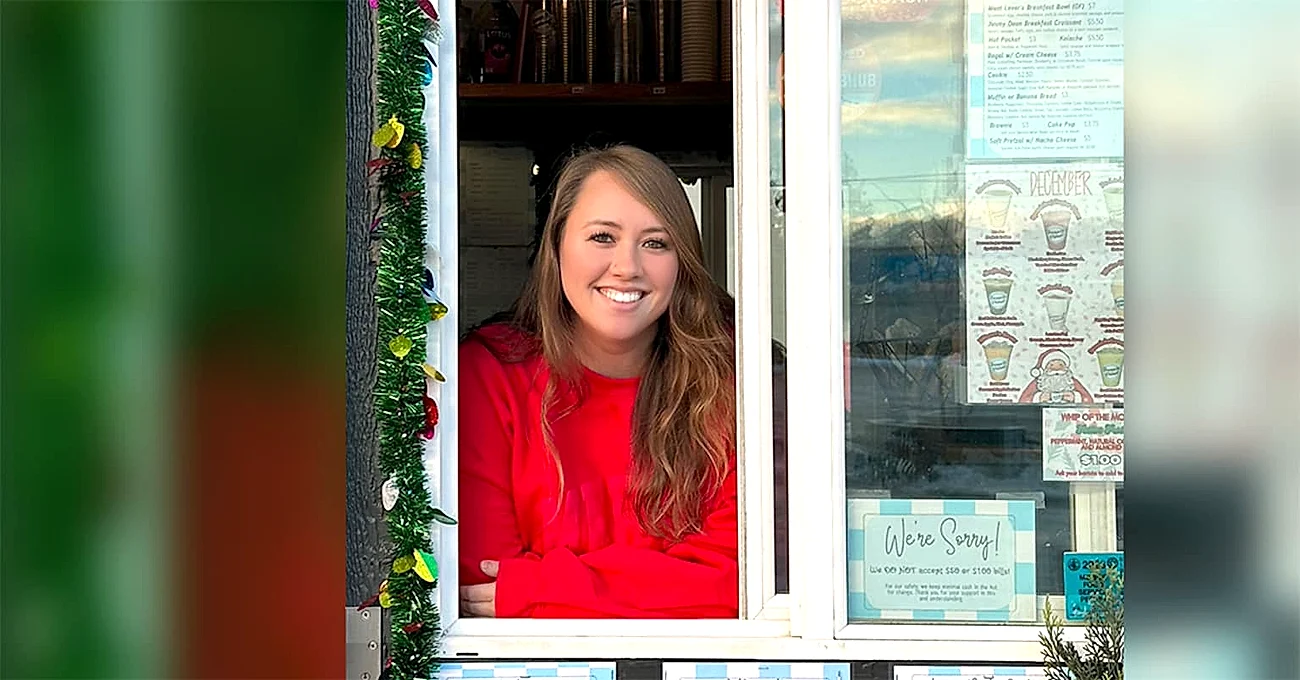 Amarin Pokrivnak, owner of Spenard Grinds, smiling out the drive-thru window